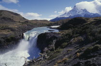 Great Falls in the National Park. White water plunging over cliff edge with snowcapped mountain peaks in the distance