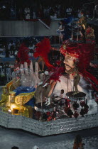 Carnival float with large model of a fortune teller and crystal ball surrounded by carnival dancers Brasil