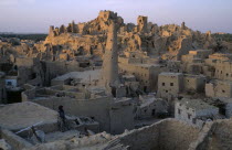 Woman sitting on rooftop with Shali Fortress behind at dusk