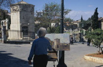 Temple of the Winds with artist standing at easel painting in the square
