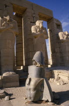 Osirid columns in front of temple with head of statue on ground