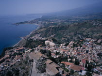 View South over the rooftops of  the town of Taormina to Giardini Naxos.