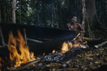 Man warps open and stretches the sides of the canoe with wedges during the burning process.Indigenous Tribes  rio Piraparana North West Amazonia Amazon American Colombian South America Vuapes Columbi...