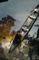 Man beaches his canoe at a river port; note fishing rod and typically shaped Amazonian paddle.Indigenous Tribes  rio Piraparana North West Amazonia Amazon American Colombian European South America Vu...