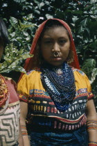 Girl wearing glass bead necklace and typical bead amulets. She also wears a typical appliqu  mola  / blouse  a gold nose ring and gold and silver ear rings  signs of considerable wealth. Gulf of Dar...