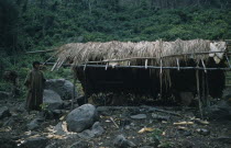 Palm thatch dwellings and shelters  boy wearing long woven cotton toga. Cultivation patch with platanos / plantains and maize plants.Indigenous Tribes Colombian / Venezuelan Border Area American Colo...