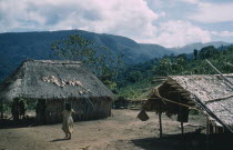 Village settlement in foothills  girl walks between two dwellings with maize growing in a cleared cultivation patch behindIndigenous Tribes Colombian / Venezuelan Border Area American Colombian South...