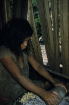 Woman grinds maize using ancient granite mortar and pestle.  The Yuko-Motilon grow 8-10 different varieties of maize.Indigenous Tribes Colombian / Venezuelan Border Area American Colombian South Amer...