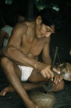Man drills holes in a gourd to make a colander for straining fruit to be made into  chicha  beer. Behind his leg another gourd is engraved with ritual figuresThe Noanama are a minority group of appro...