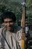 Man clutching hardwood bow and quiver of steel-headed arrows for mammals and birds  clay pipe for tobacco  wearing woven cotton  manta   / cloak.Indigenous Tribes American Colombian South America Col...