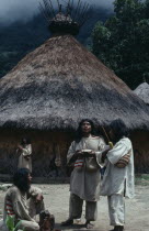 Chendukua traditional village Kogi mamas/priests stand outside ceremonial nuhue/ temple with grass-thatched roof and rack at apex filled with sacred potsherds   southern side of Sierra Chendukua Indig...