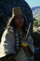 Kogi mama/priest Juan Vacuna wearing distinctive woven fique/cactus fibre hat at religious centre of Surlivaka  Holds lime encrusted poporo/gourd full of fine lime powder from burnt seashells collecte...