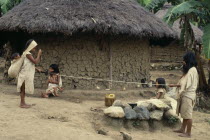 Parque Nacional. Kogi-Wiwa family spinning rope from strands of fique cactus fibre. Mother holds spindle and spins whilst father holds out extended new rope. Two young daughters look on whilst baby so...