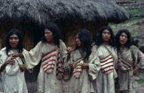Chendukua. A group of Kogi men outside a grass-thatched village home on S.side of Sierra. Drunk on aguadiente/distilled sugarcane liquor -sold to Indians by Colombian campesinos/peasants Hand-woven wh...