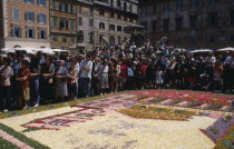 Santa Maria in Trastevere with crowds gathered for display of flower petal mosaic in Piazza di Santa Maria during Infiorata di Gerano.