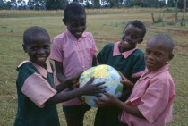 Schoolchildren holding a globe.