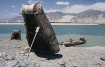 Near Tsetang. Yak skin boats  one propped up by a paddle  and a local ferry beside the Yarlung Tsangpo  Brahmaputra River.