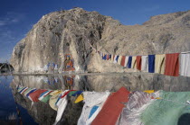 Carved Buddha  Buddhist paintings and prayer flags on a rock wall by the road from Lhasa to the airport.