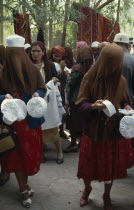 Veiled women selling hats amongst the crowd at the Sunday Market.