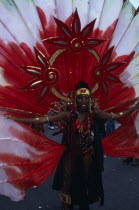 Notting Hill carnival woman in extravagant red costume.Nottinghill