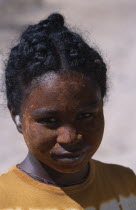 Ifaty Beach. Head and shoulders portrait of a young girl wearing mud mask on her face to protect her skin from the sun