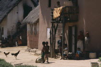 Road to Ranomanfana. Women and children in village with thatched huts and cockerels roaming freely
