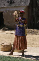 Road to Ranomanfana. Woman wearing a Los Angeles Lakers Basketball team shirt sprinkling corn