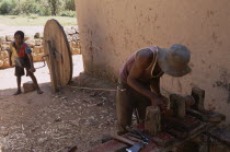 Artisan carving rosewood using child powered lathe