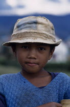 Road to Ambositra. Portrait of a young boy wearing a dirty hat and blue knitted sweater
