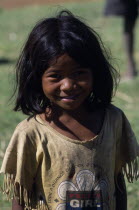 Portrait of a smiling child wearing a dirty t shirt printed with the slogan Pretty Girl