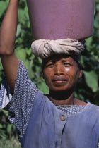 Portrait of a woman carrying a water bucket on her head