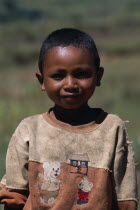 Portrait of a young boy wearing a dirty shirt printed with teddy bears