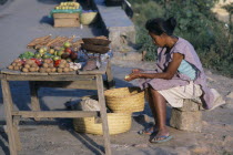 Woman selling fruit and vegetables on a roadside stall