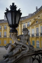 Detail of carved stone balustrade and lamp with part view of curved exterior of palace behind.