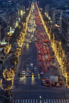 Les Champs Elysees at night with illuminated shop fronts and traffic lights.