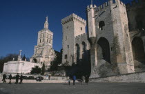 Avignon.  Palais des Papes and Cathedral Notre Dame des Doms with visitors in courtyard below.