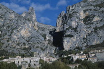 Sillans village at foot of steep eroded cliffs.