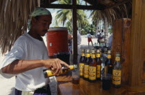 Man pouring rum into a glass at a Tiki style bar