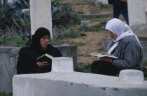Female family members reading the Koran over son s grave. Moslem