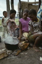 Women cooking cassava over wood burning fire. Zaire