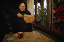 Elderly widow cutting bread.
