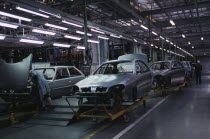 Cars on trolleys awaiting completion in a production factory
