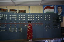 The main hall of the hydroelectric power station  a woman taking readings from the control panel.  hydropower