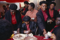 Female members of Burial Society or Stokvel counting money.  Funerals are seen as an important part of culture and tradition and are costly  often lasting several days.community