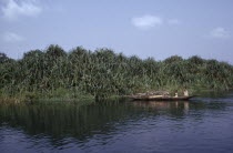 Woman and children in canoe carrying wood on the River Ethiope.