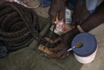 Cropped shot of vendor cutting piece of tobacco at stall.