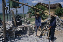 Construction workers next to rock crushing machine.casseurs du pierre