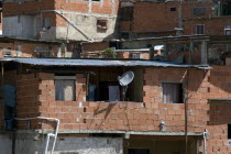 Dwelling in La Planicie community complete with satellite TV dish  above main highway leaving the hillside town and en route to La Guaira and the national airport