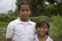 Two young girls wearing white t shirts.