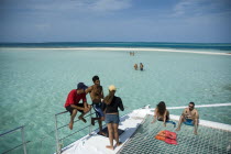 Day trippers aboard catamaran  with Rasqui cay in background.